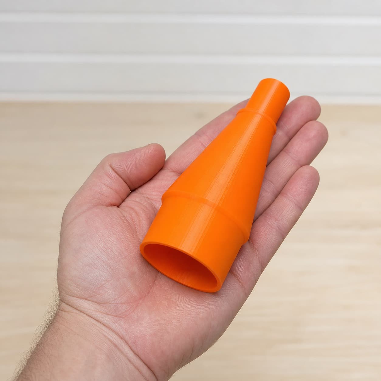 The DBO380 to 1.875" Duct dust adapter held in one hand to show its size