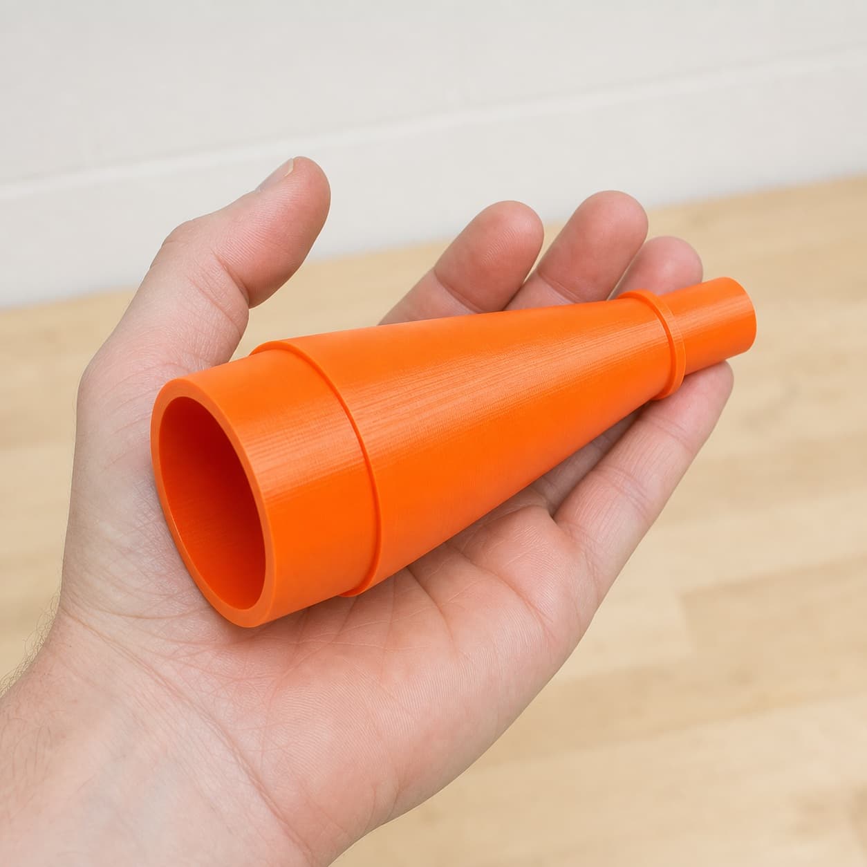 The DBO380 to Bauer 6G Vac dust adapter held in one hand to show its size