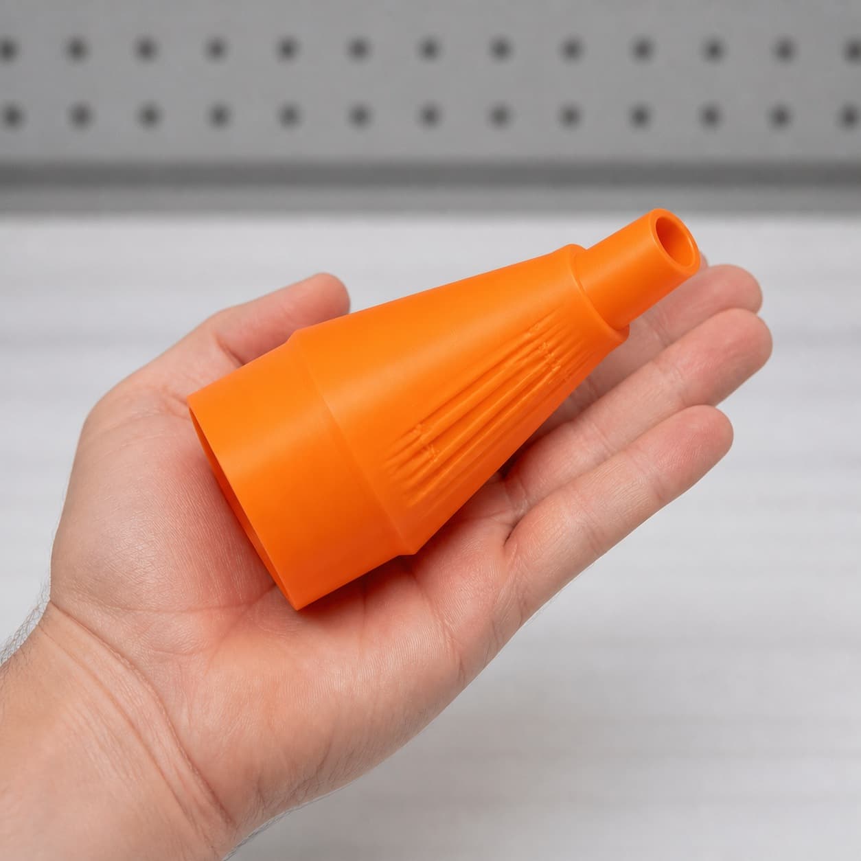 The DJV182 to Bauer 6G Vac dust adapter held in one hand to show its size