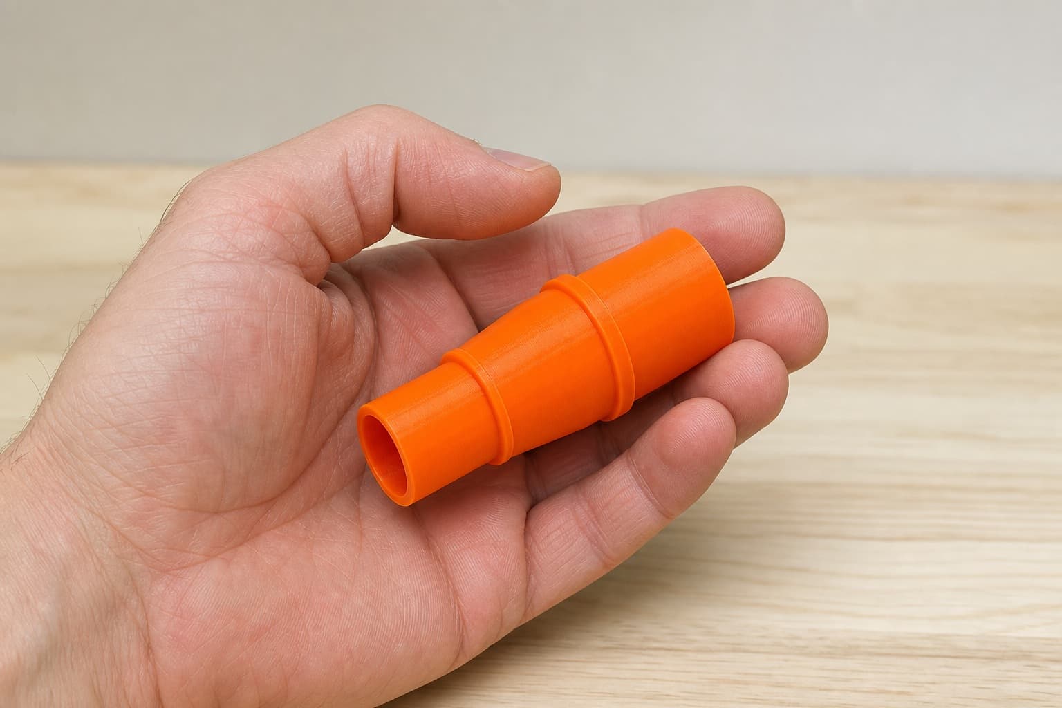 The XOB01Z to 1.25" Duct dust adapter held in one hand to show its size