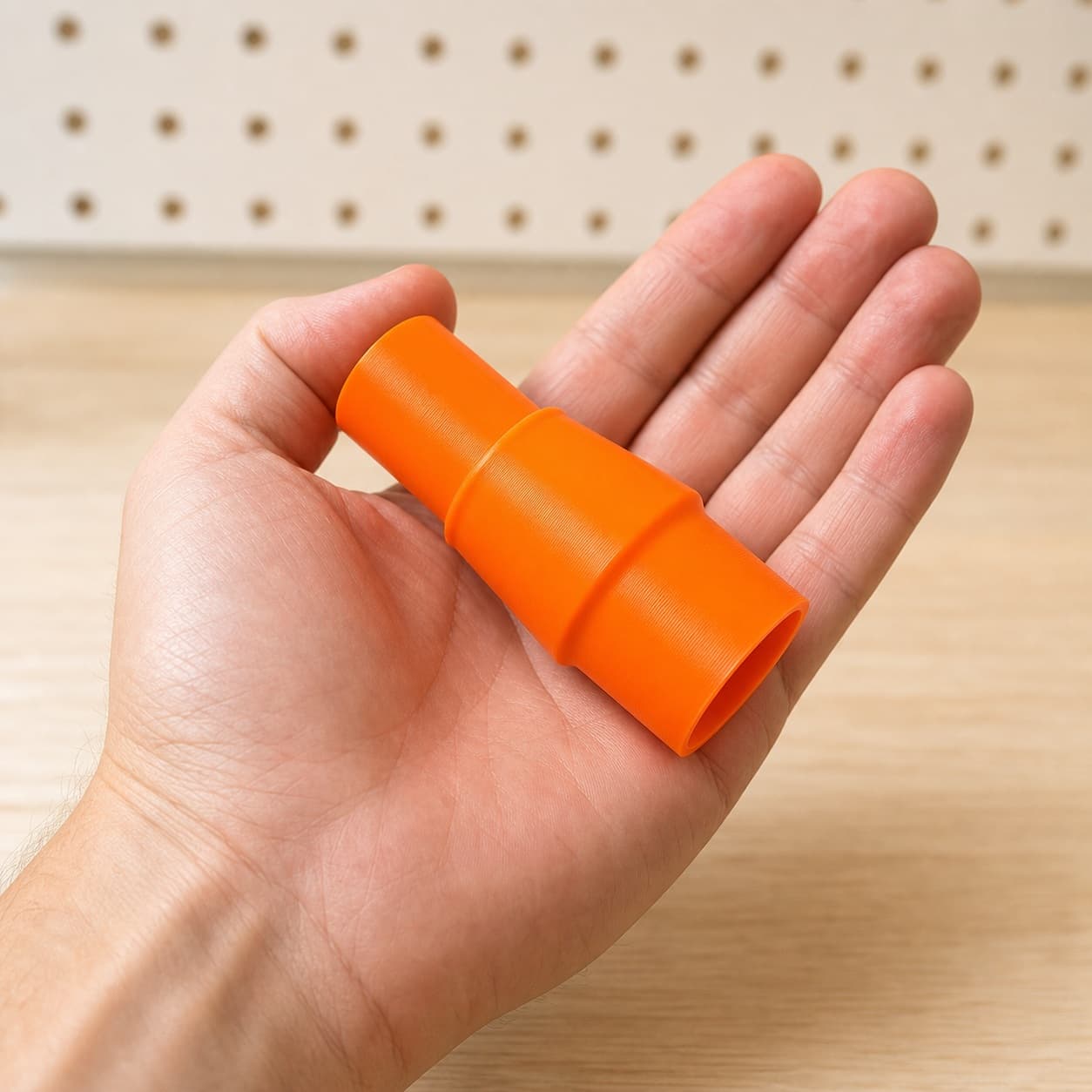 The BO5041 to DeWalt DWV010 dust adapter held in one hand to show its size