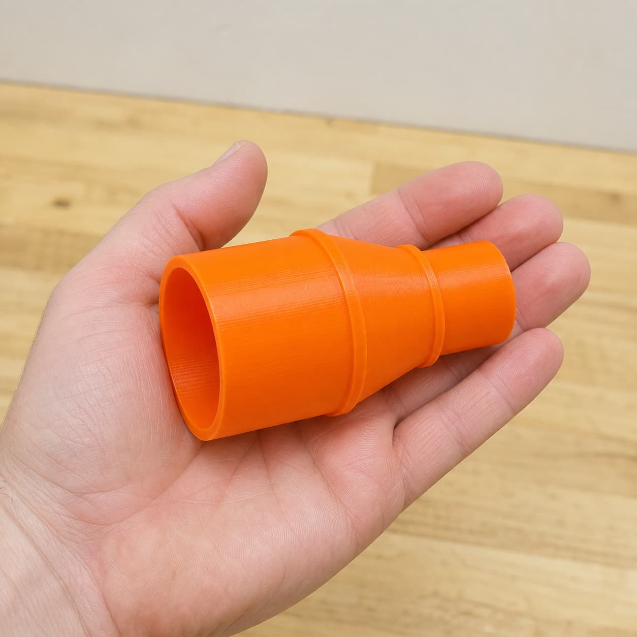 The BO6030 to Festool CT 36 dust adapter held in one hand to show its size