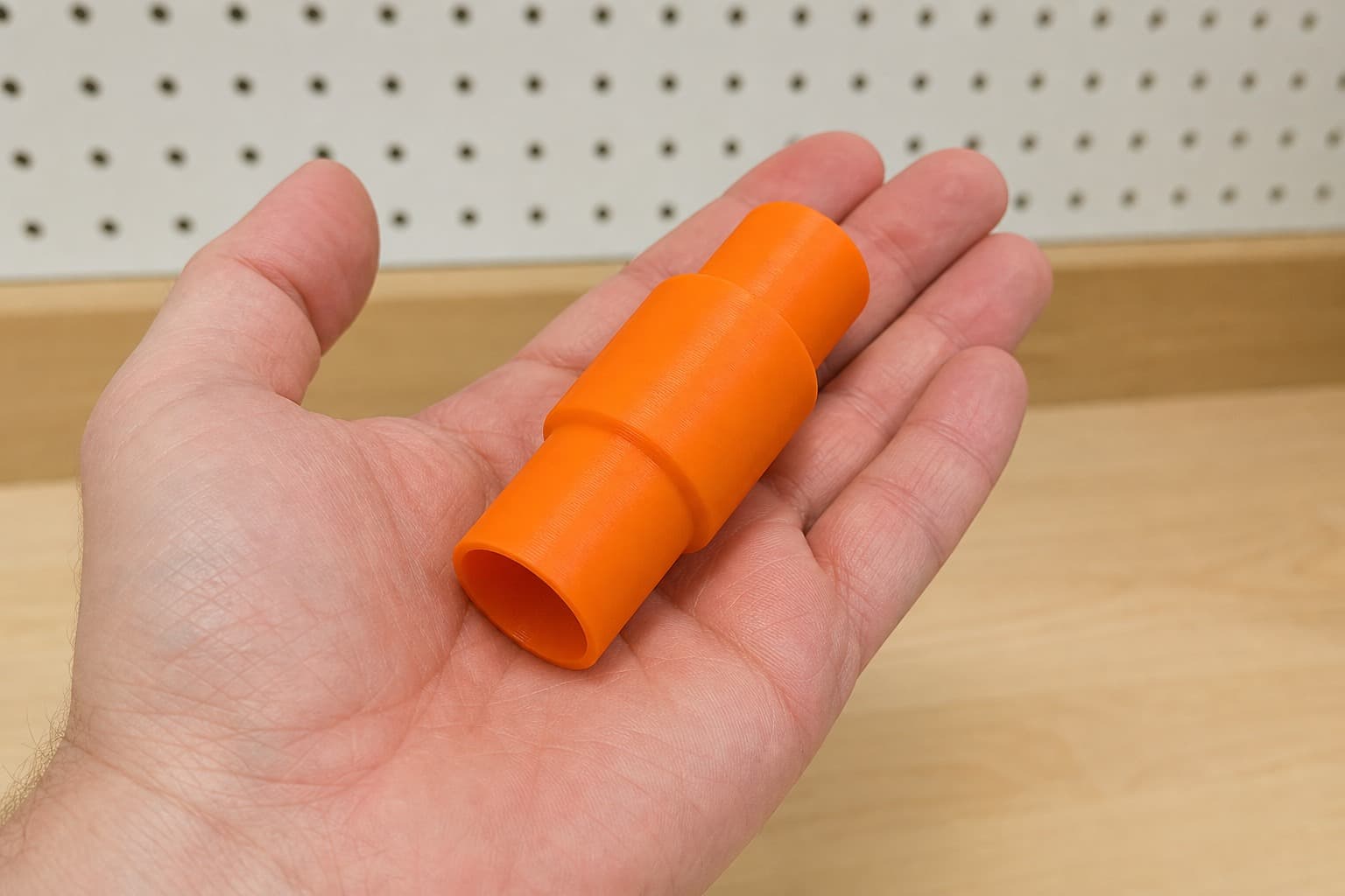 The Origin to 27mm Festool dust adapter held in one hand to show its size