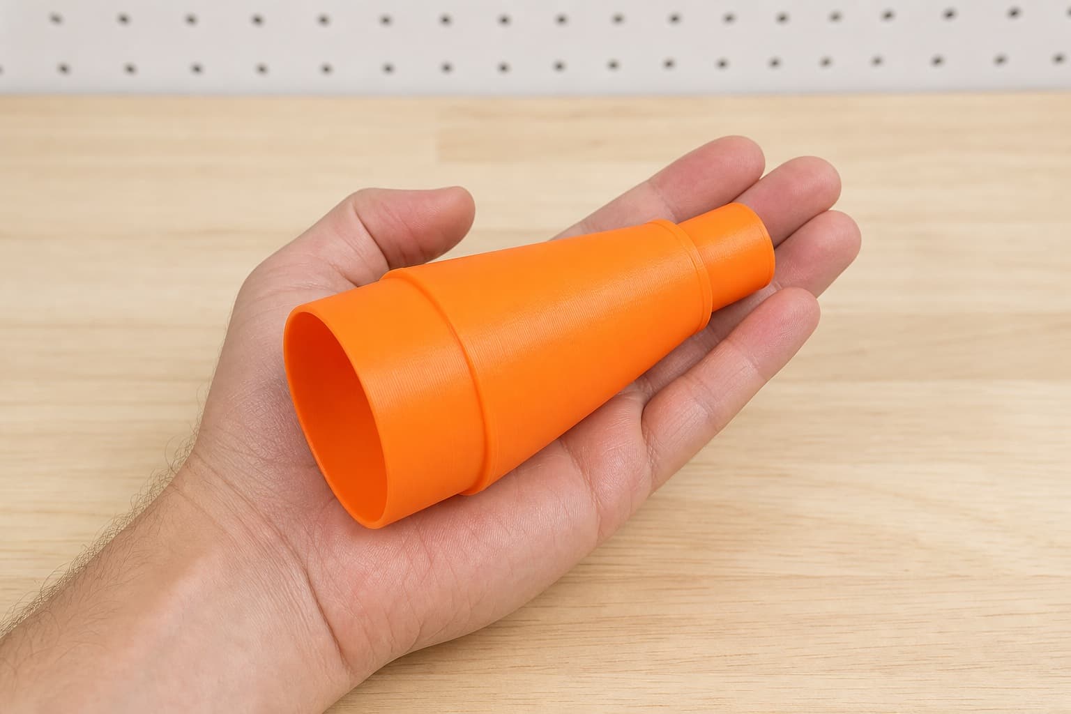 The 576014 to Craftsman 16G dust adapter held in one hand to show its size