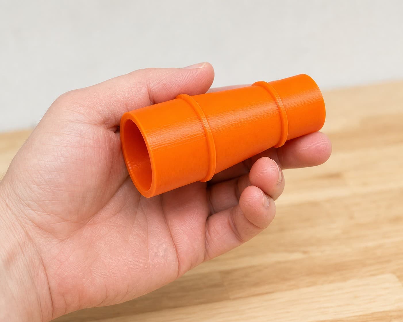 The DCS355B to 1" Duct dust adapter held in one hand to show its size