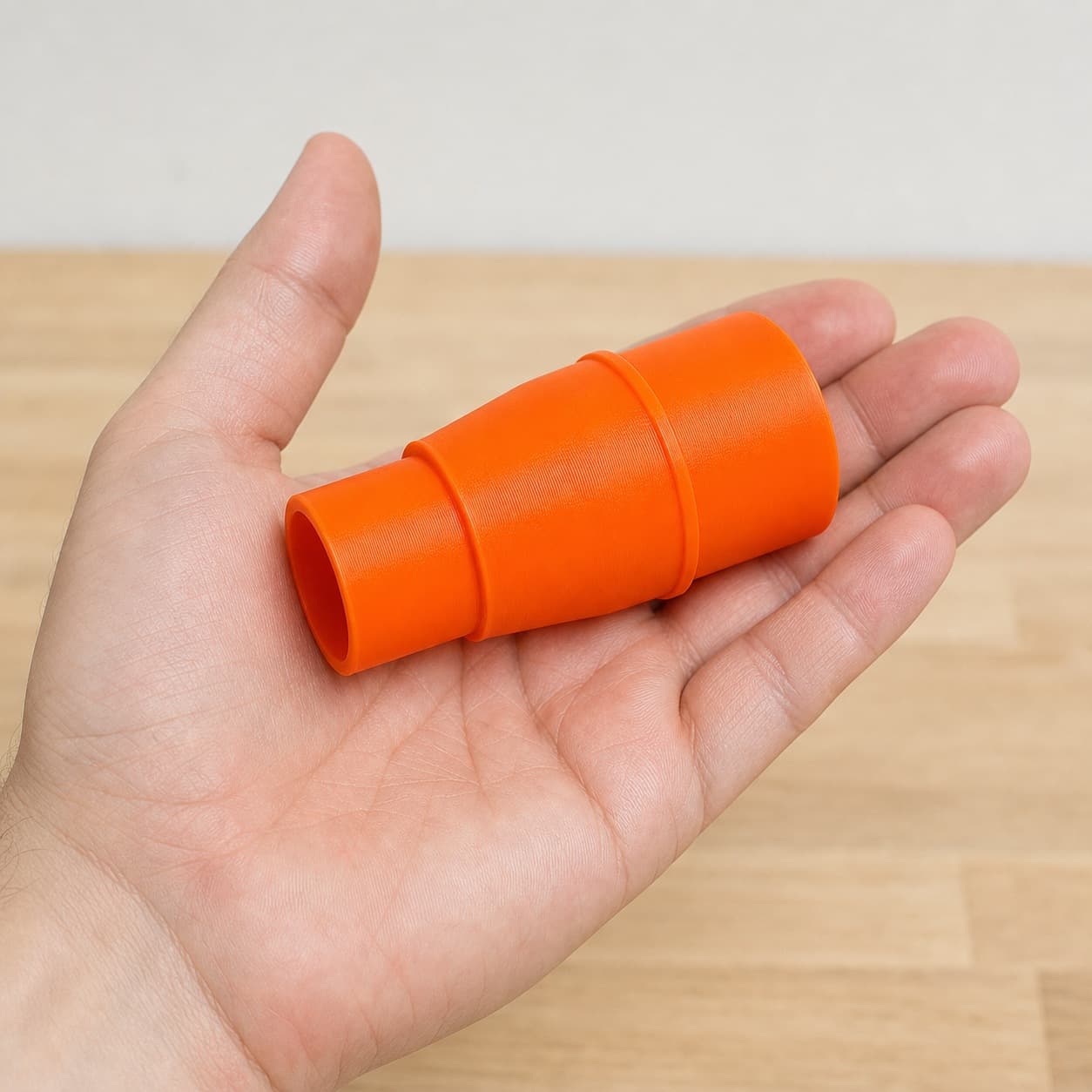 The PCL505B to 1.5" Duct dust adapter held in one hand to show its size