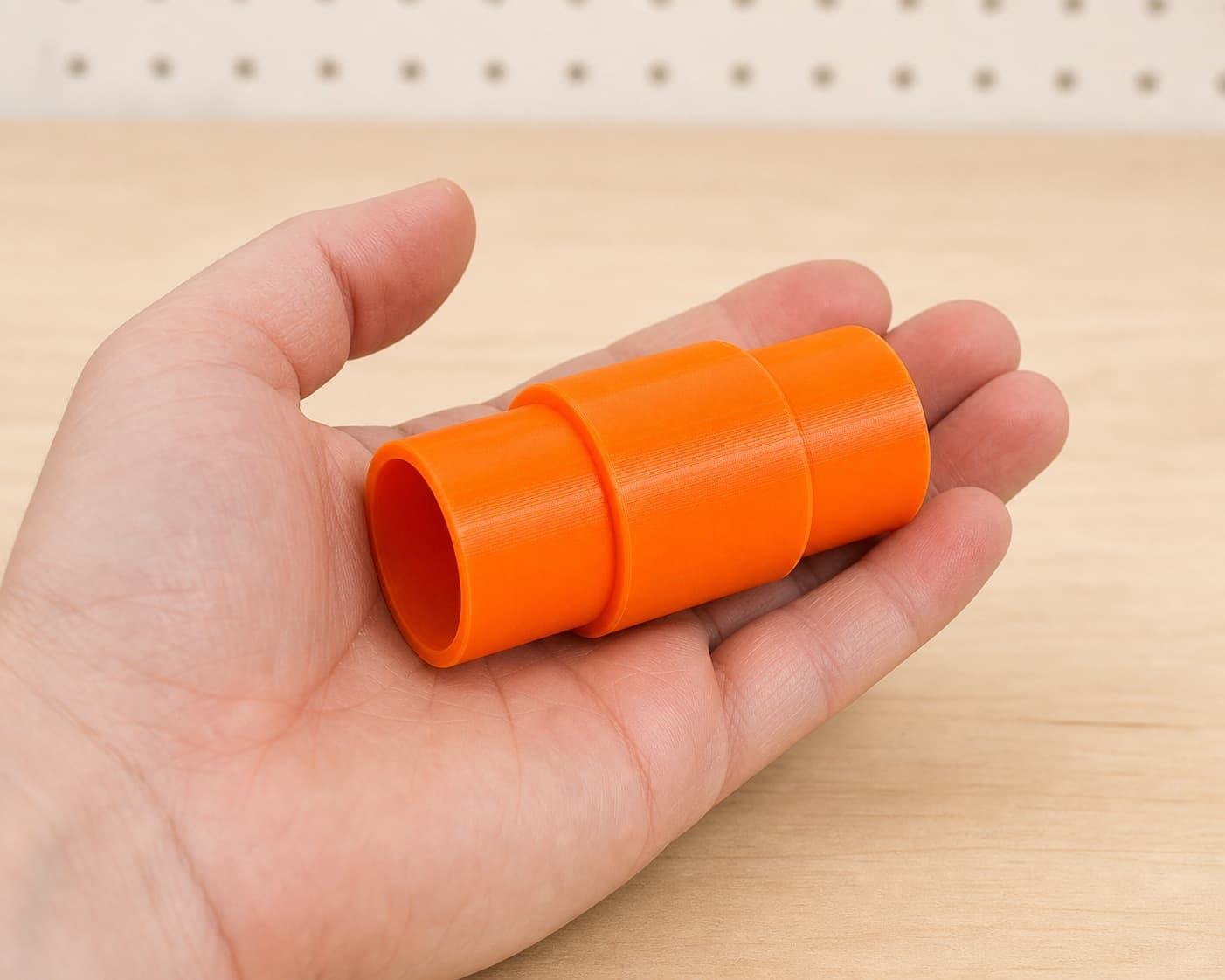 The RP2303FC to 1.25" Duct dust adapter held in one hand to show its size