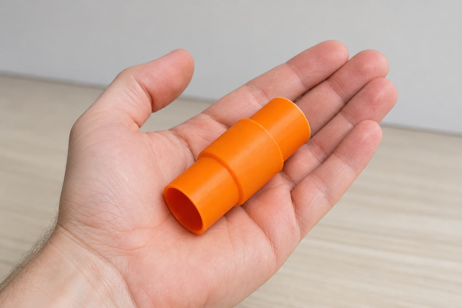 The RP2303FC to Bosch GAS18V-3N dust adapter held in one hand to show its size