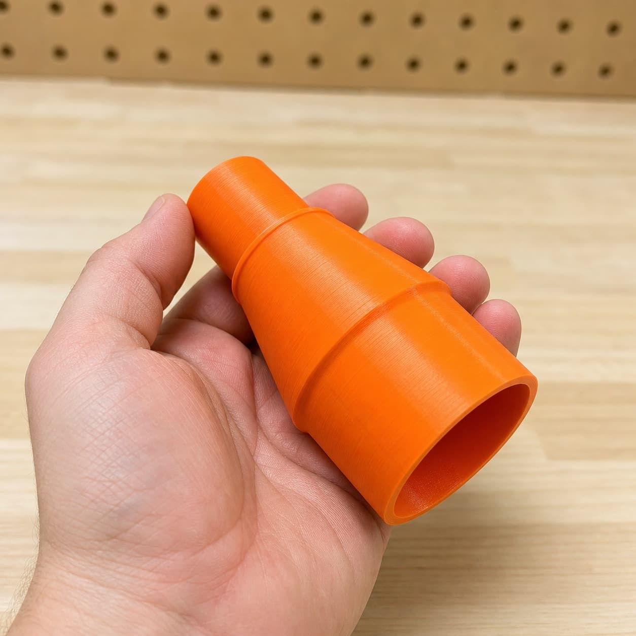 The RT0702C to M18 6G Vac dust adapter held in one hand to show its size