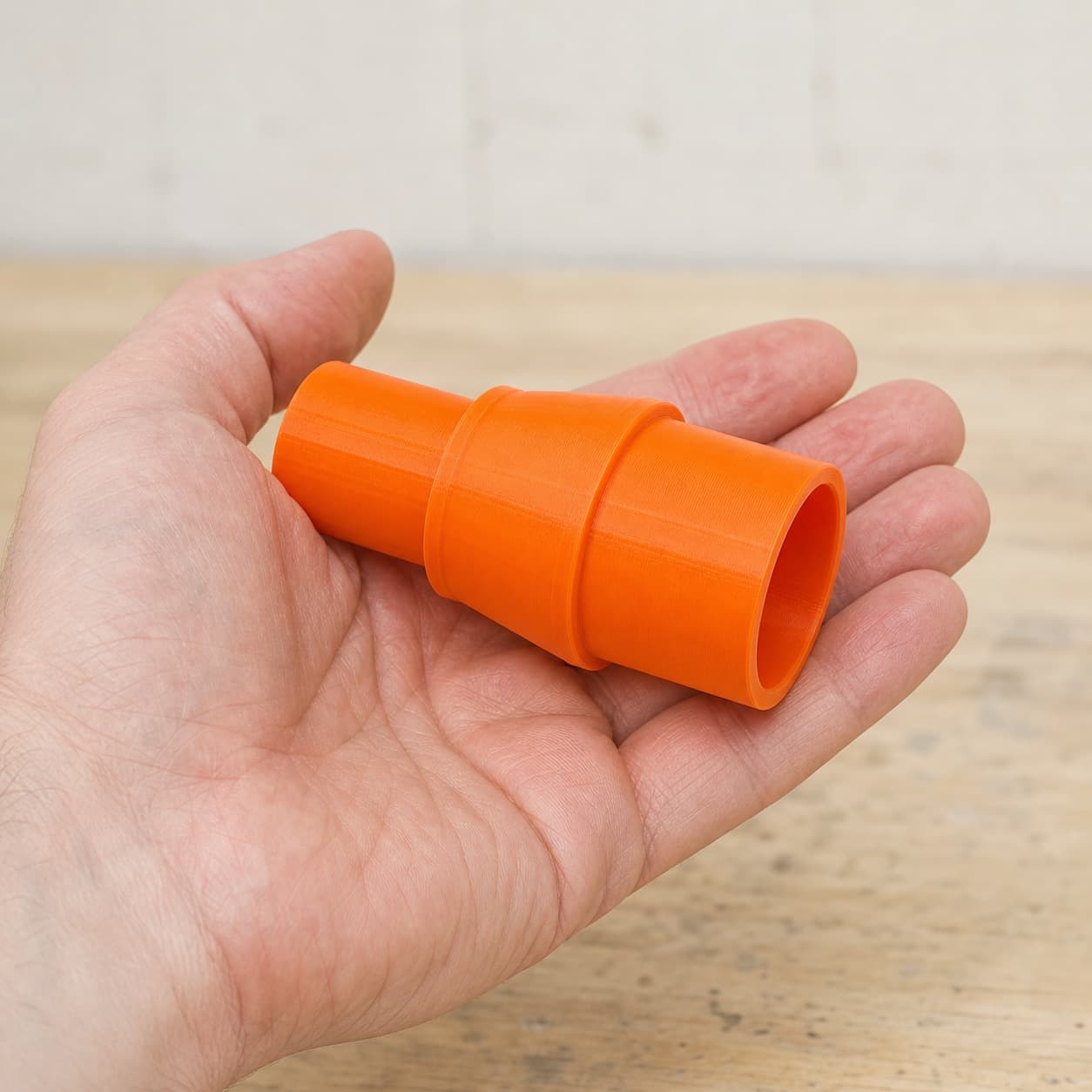 The 352VS to 27mm Festool dust adapter held in one hand to show its size