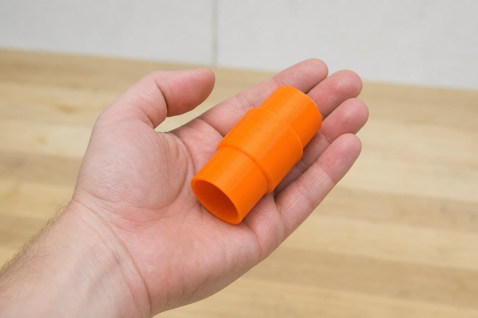 The DWS780 to 36mm Festool dust adapter held in one hand to show its size