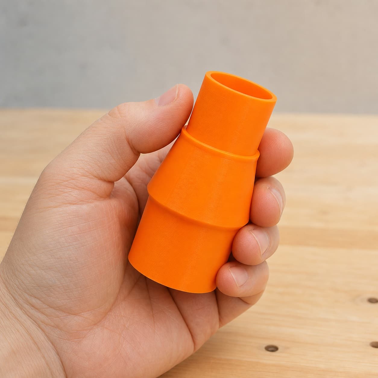 The DWS780 to 1.875" Duct dust adapter held in one hand to show its size