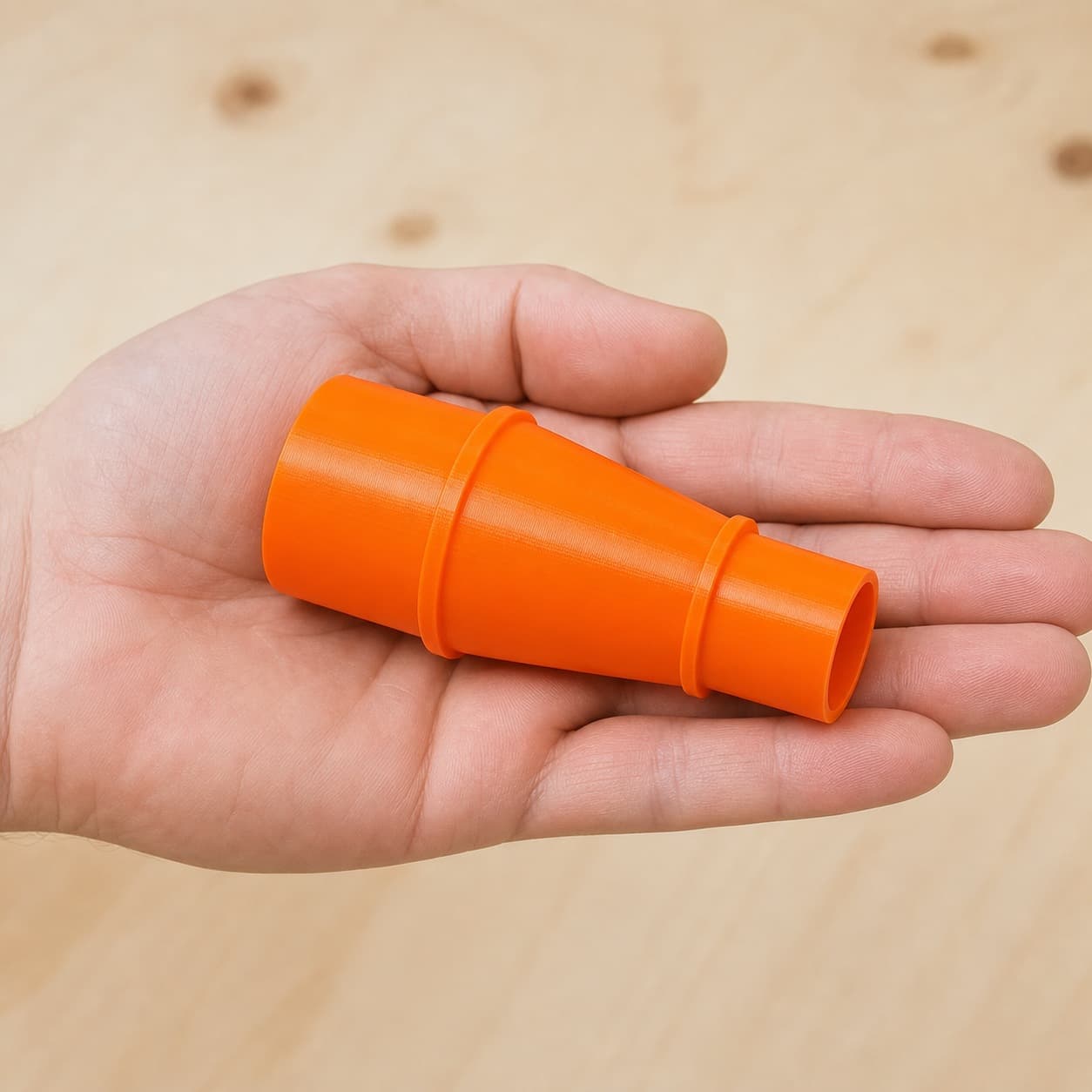 The TP-CS 18/190 Li to 27mm Festool dust adapter held in one hand to show its size