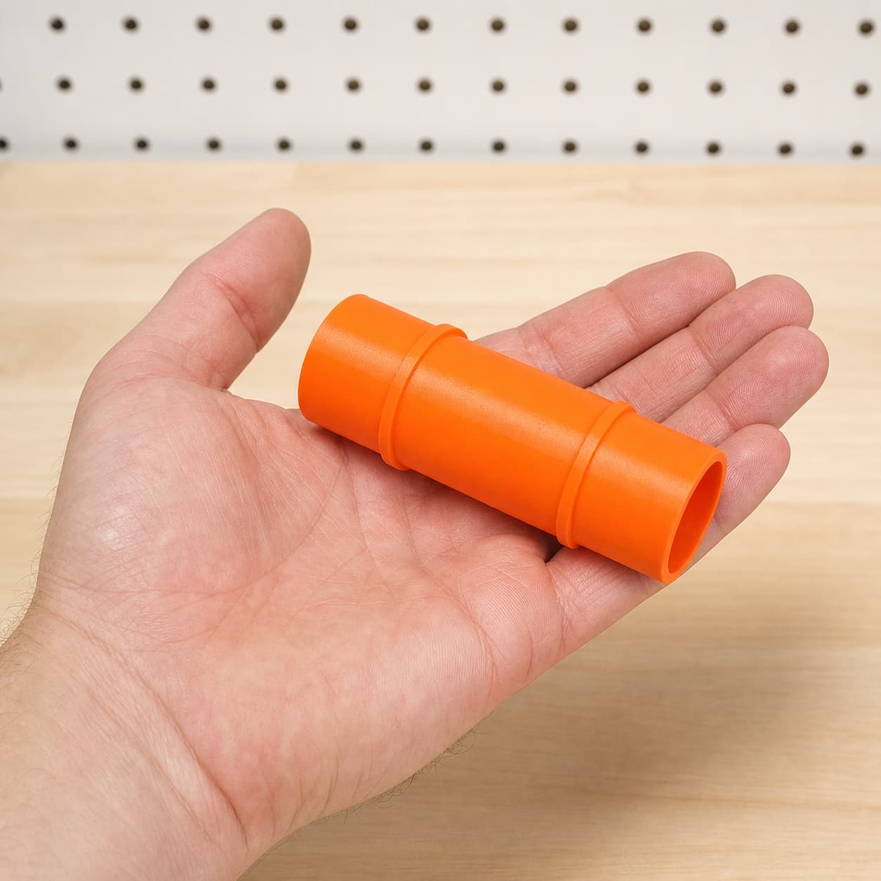 The GET75 to Makita XCV11Z 2G dust adapter held in one hand to show its size