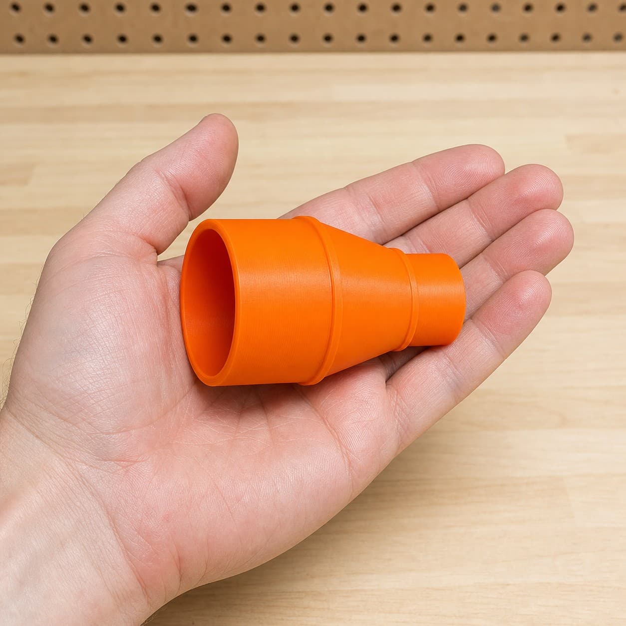 The C18DBALP4 to 2" Duct dust adapter held in one hand to show its size