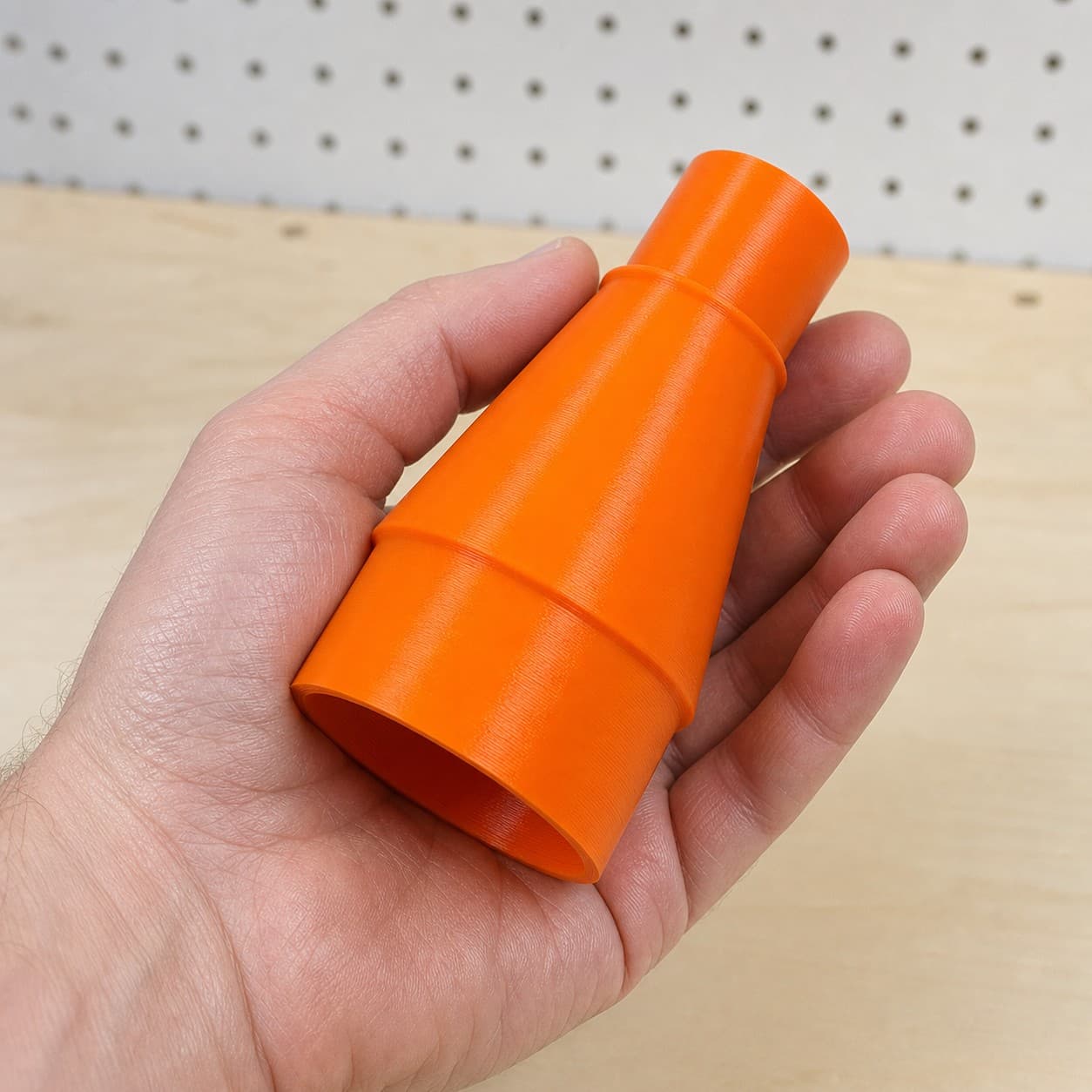 The GET75 to 2.5" Duct dust adapter held in one hand to show its size
