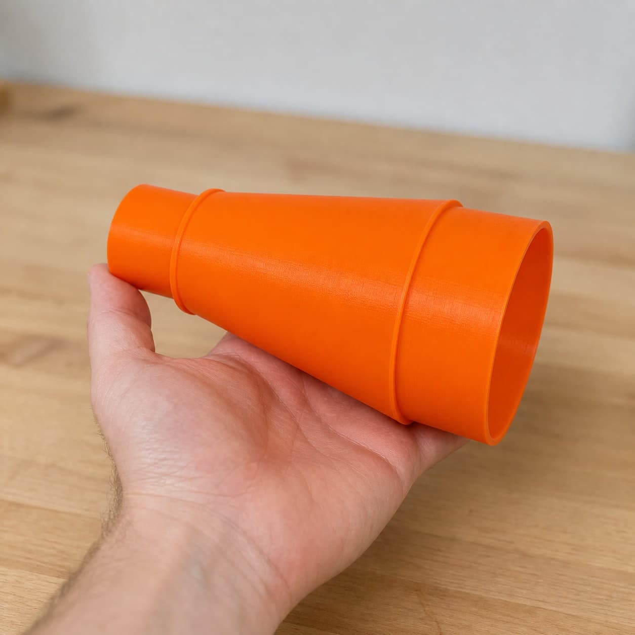 The 50-114 to 3" Duct dust adapter held in one hand to show its size