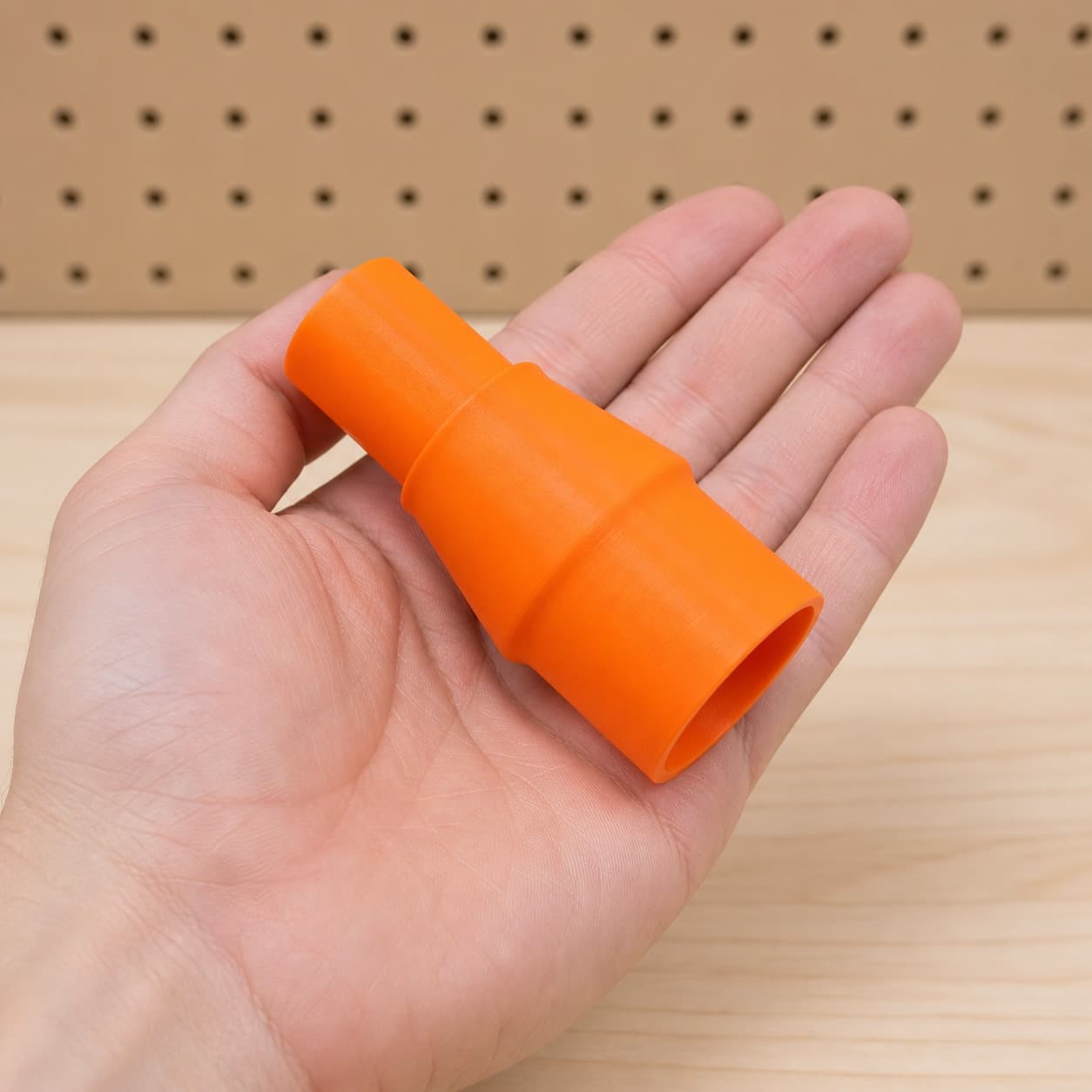 The XSH06Z to Festool CT MIDI dust adapter held in one hand to show its size