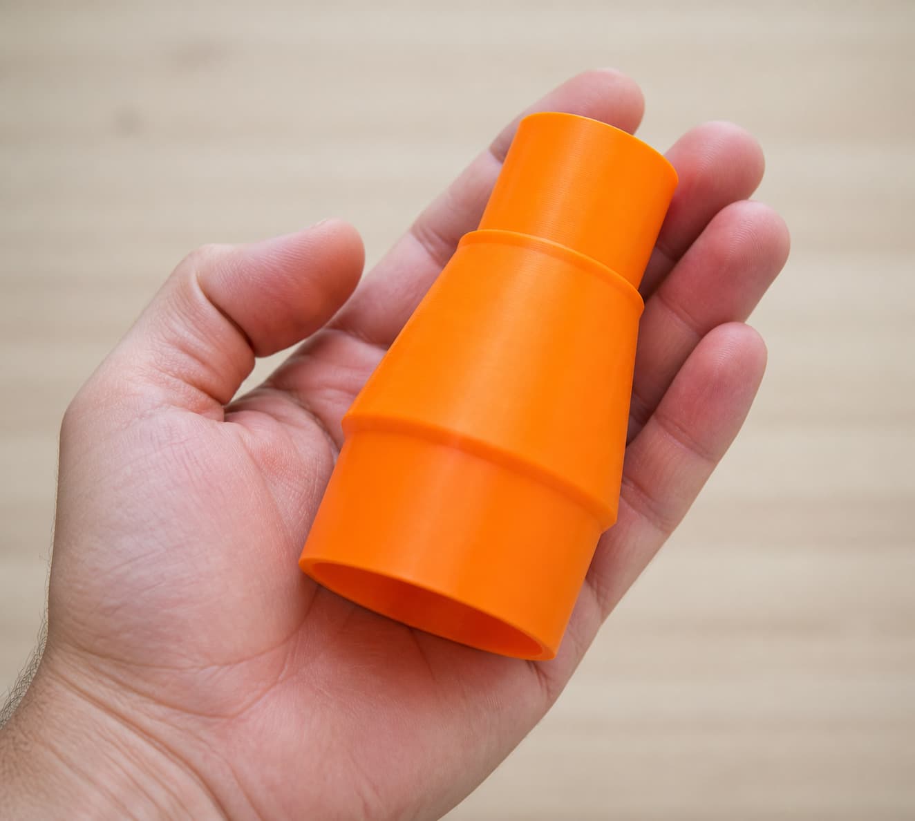 The XSH06Z to Bauer 6G Vac dust adapter held in one hand to show its size