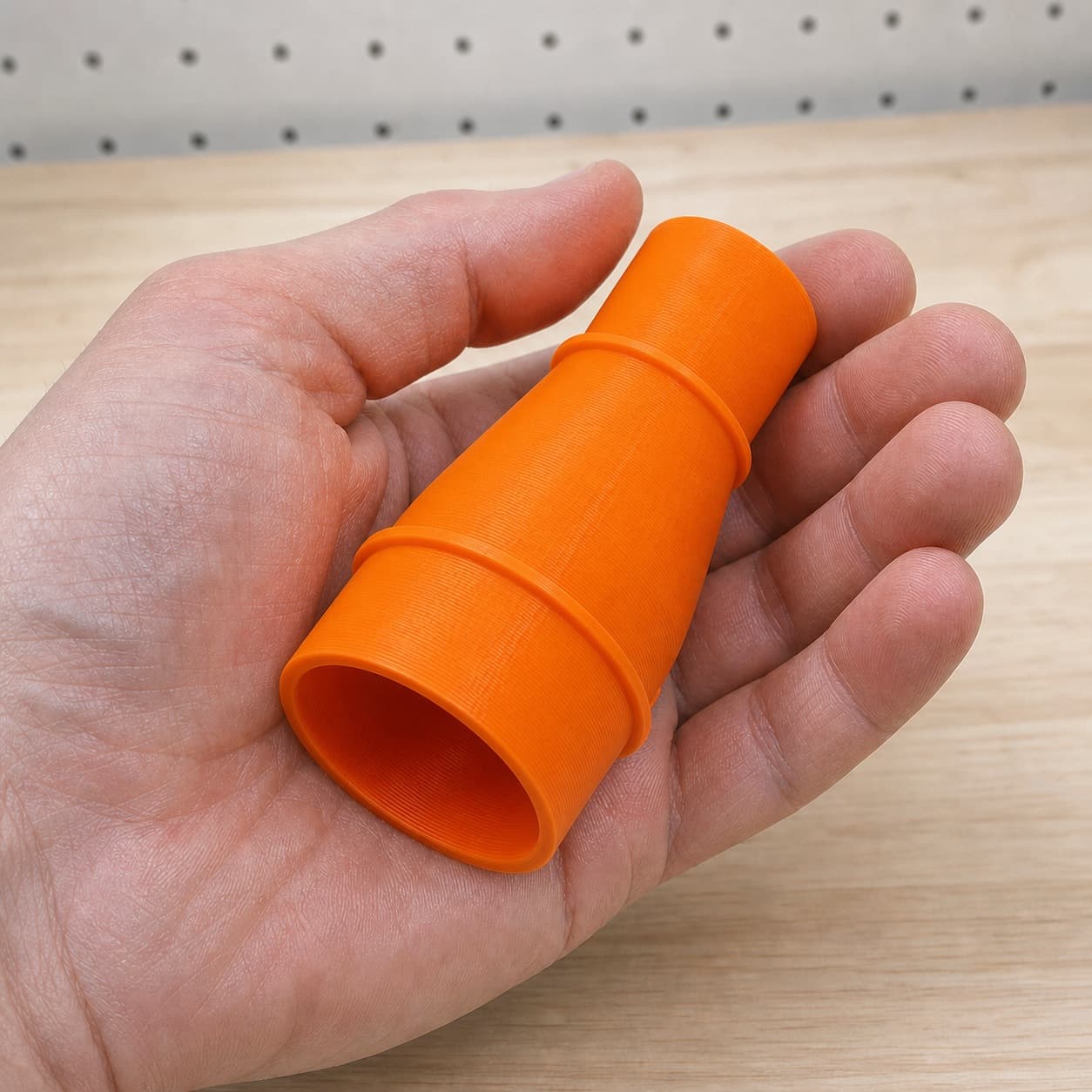 The TSS102L to Craftsman 20G dust adapter held in one hand to show its size