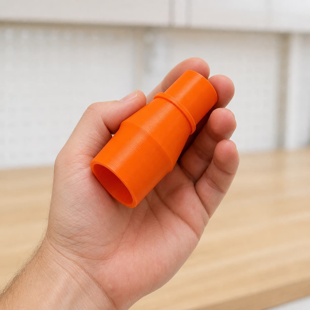 The 69033 to Festool CT 15 dust adapter held in one hand to show its size