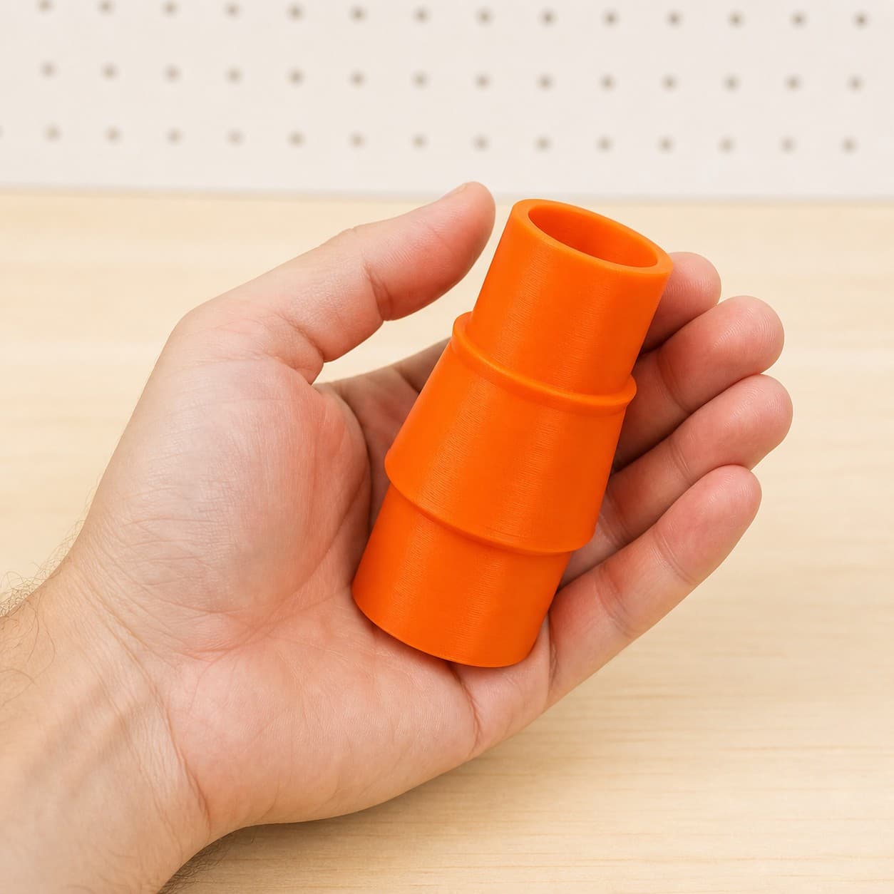 The 3386-01 to 1.25" Duct dust adapter held in one hand to show its size