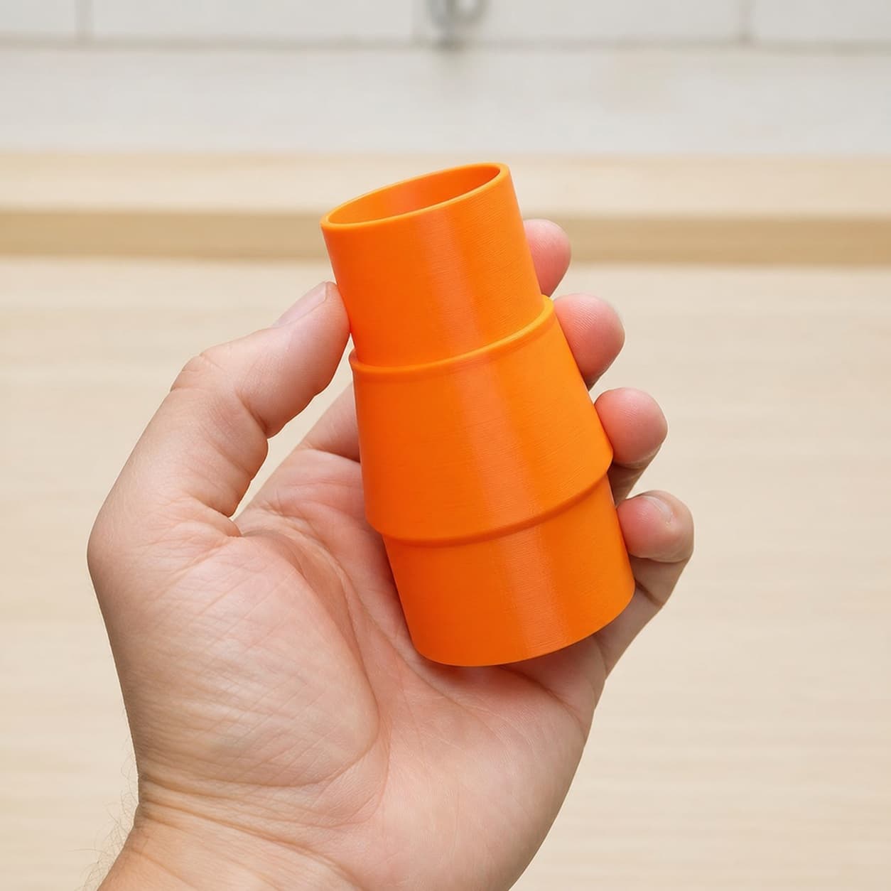 The 3386-01 to 1.875" Duct dust adapter held in one hand to show its size