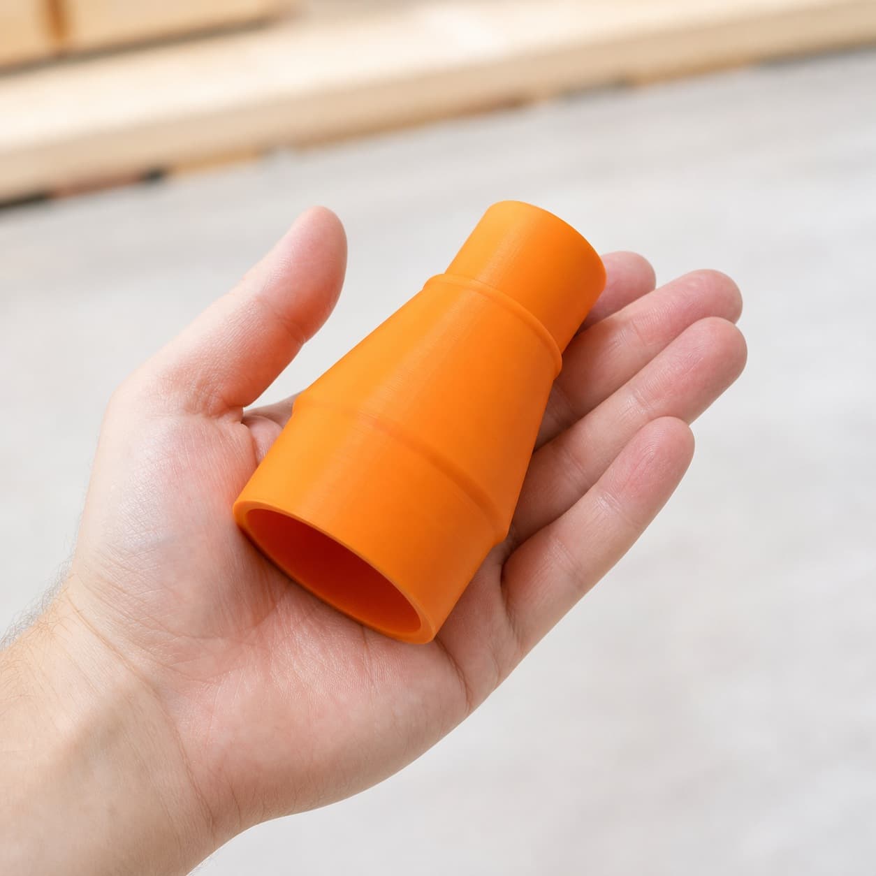 The 69033 to Bauer 6G Vac dust adapter held in one hand to show its size