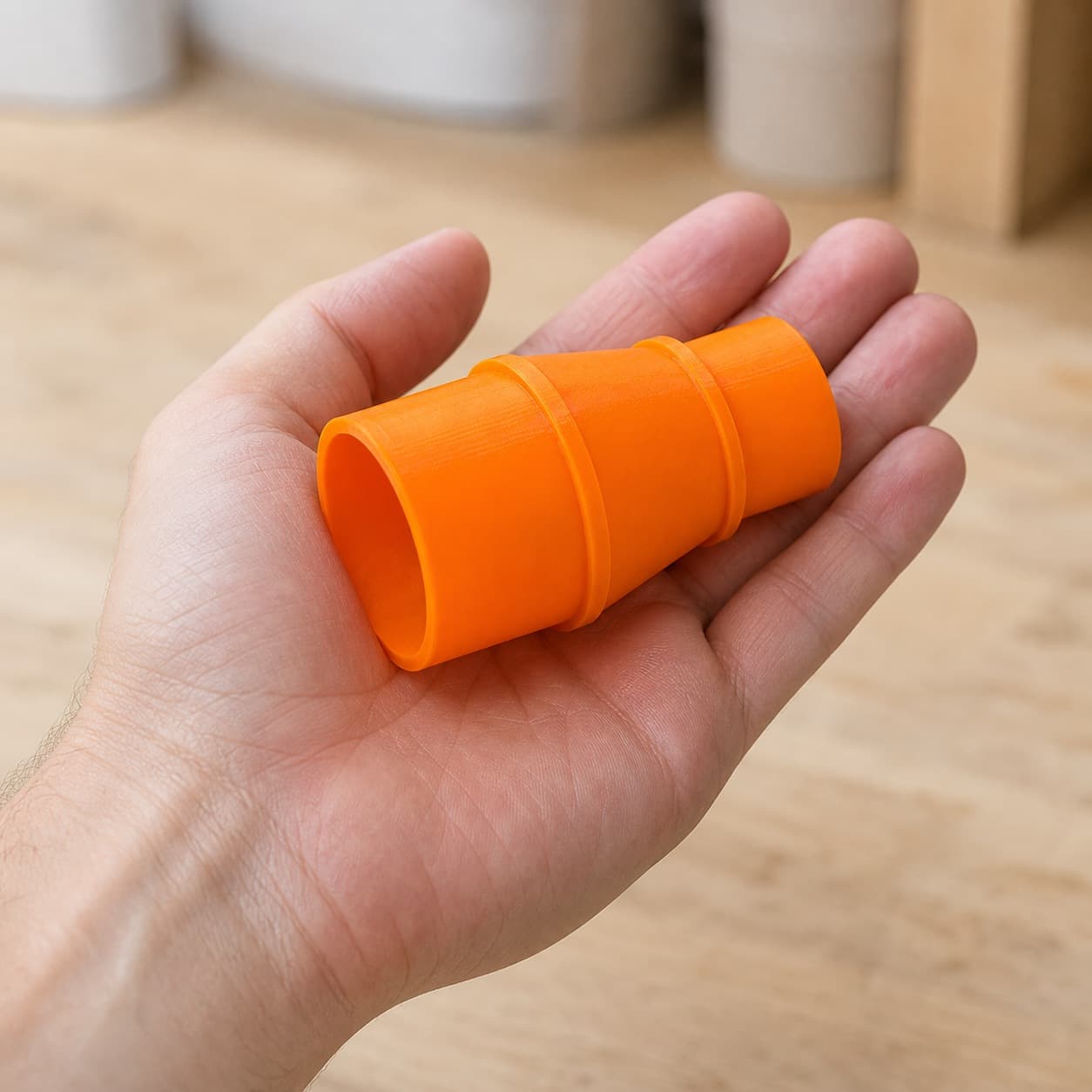 The R8606B to Craftsman 20G dust adapter held in one hand to show its size