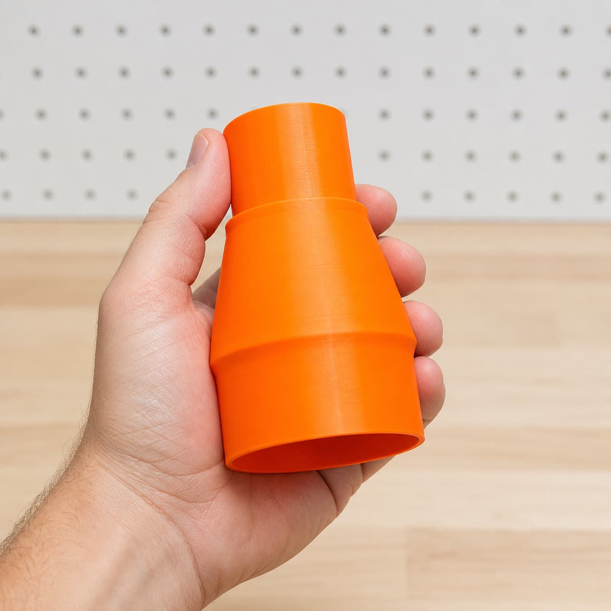 The R8606B to Bauer 6G Vac dust adapter held in one hand to show its size