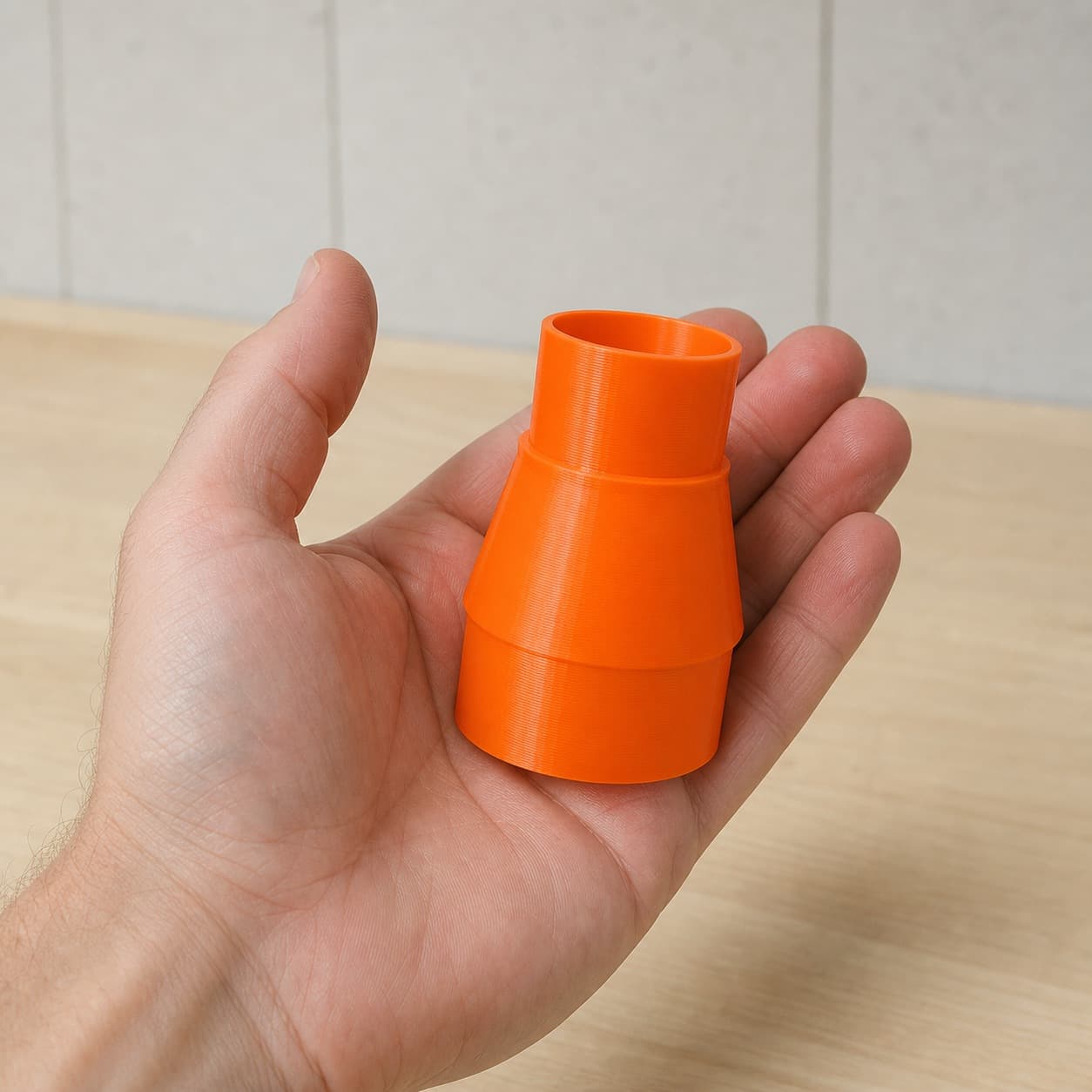 The KGS 216 M to Bauer 6G Vac dust adapter held in one hand to show its size