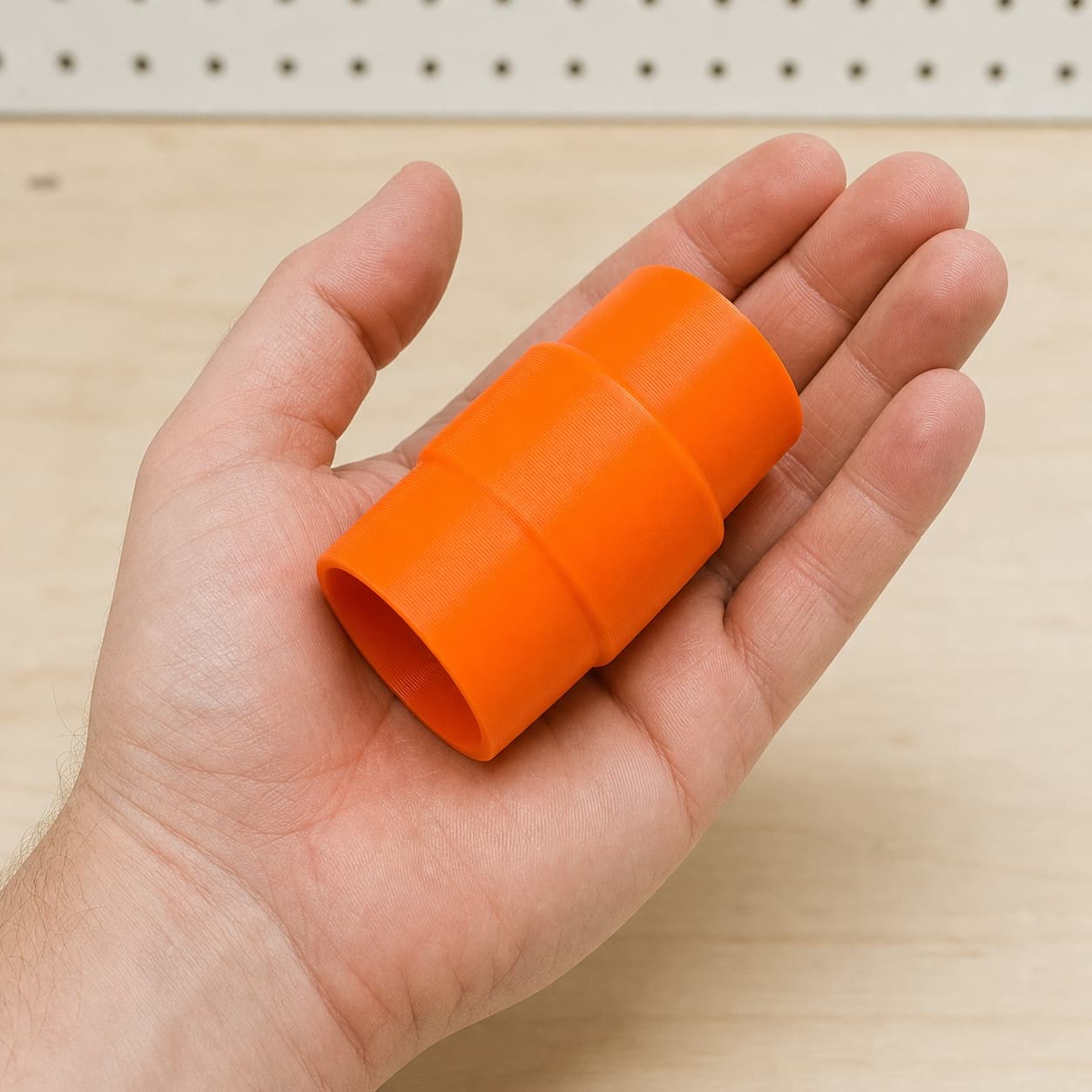 The GCM12SD to M18 9G Vac dust adapter held in one hand to show its size