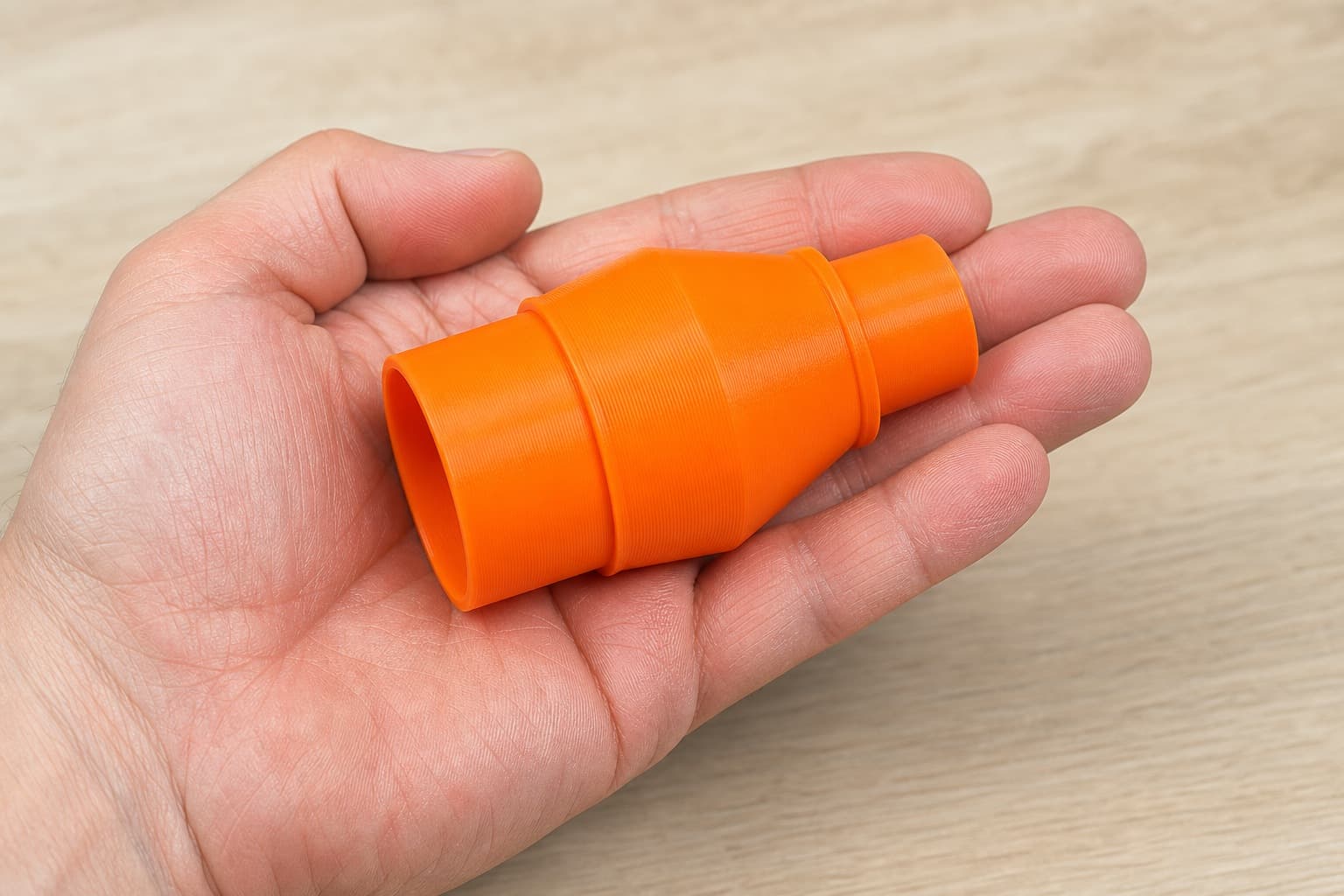 The KP0810 to 1.25" Duct dust adapter held in one hand to show its size