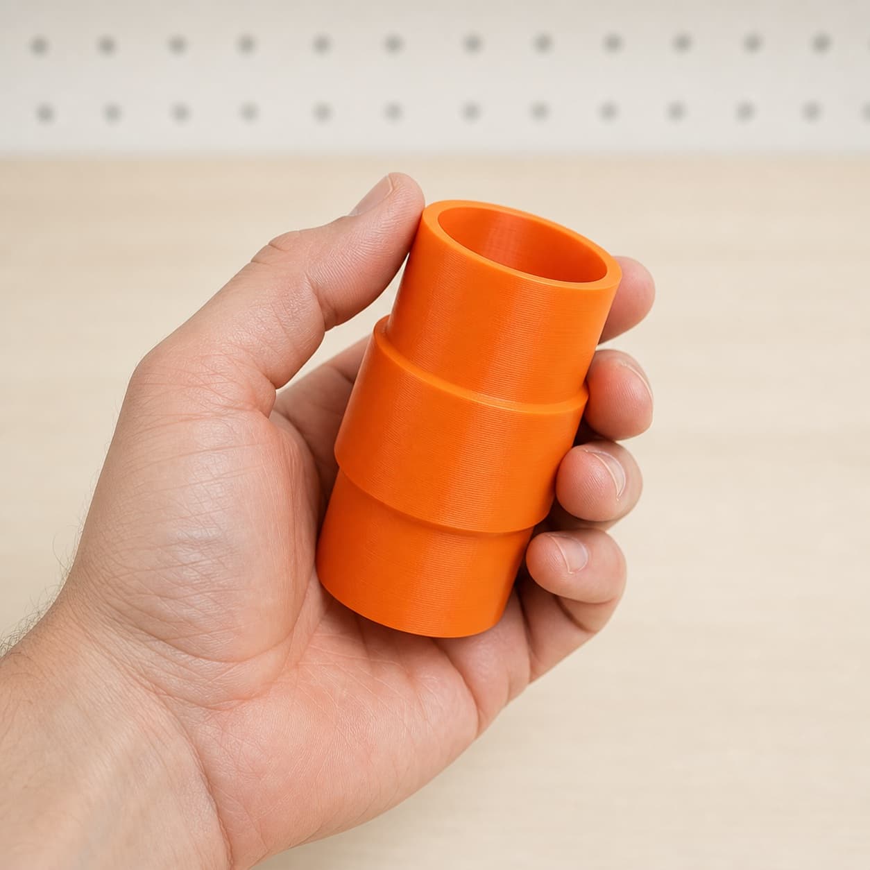 The DKP180 to M18 6G Vac dust adapter held in one hand to show its size