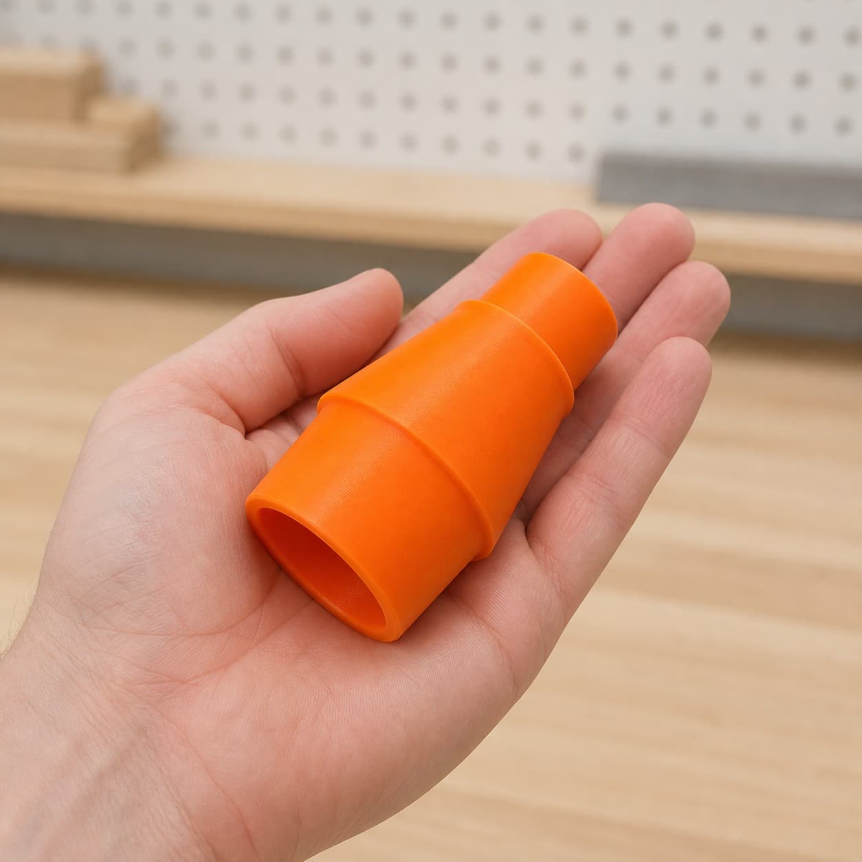The 58862 to 1.25" Duct dust adapter held in one hand to show its size