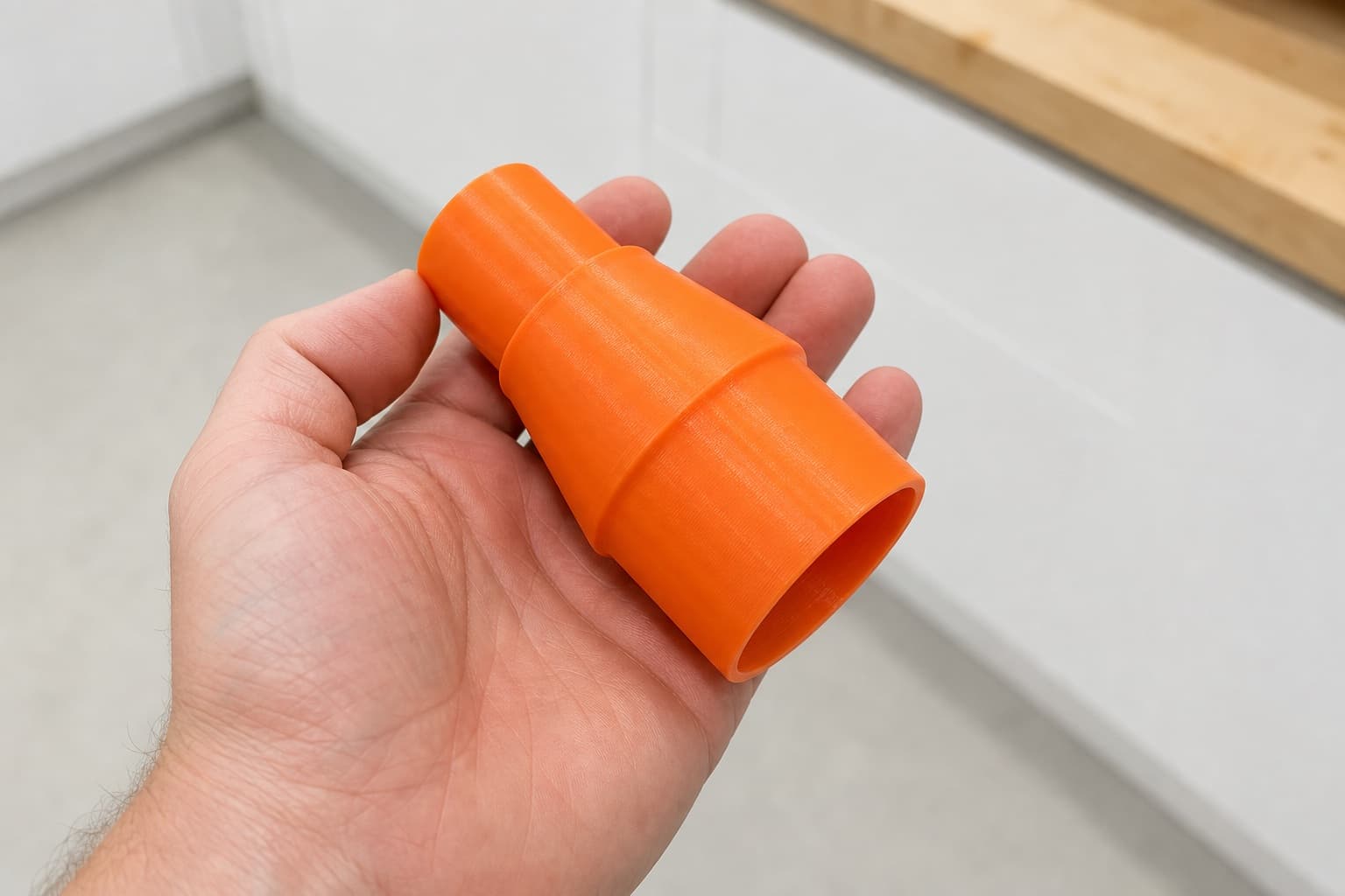 The 58862 to Makita XCV11Z 2G dust adapter held in one hand to show its size