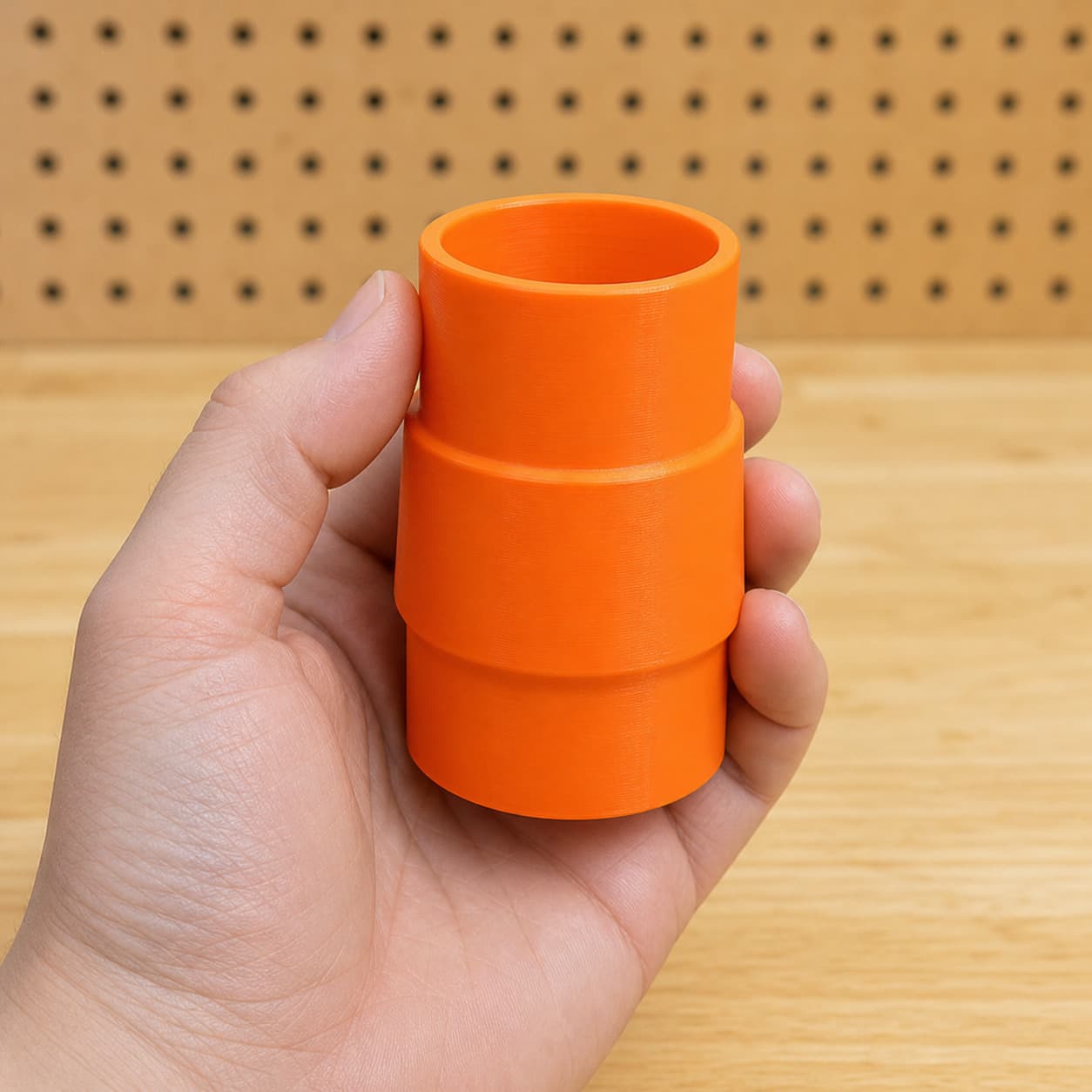 The 58862 to 1.875" Duct dust adapter held in one hand to show its size