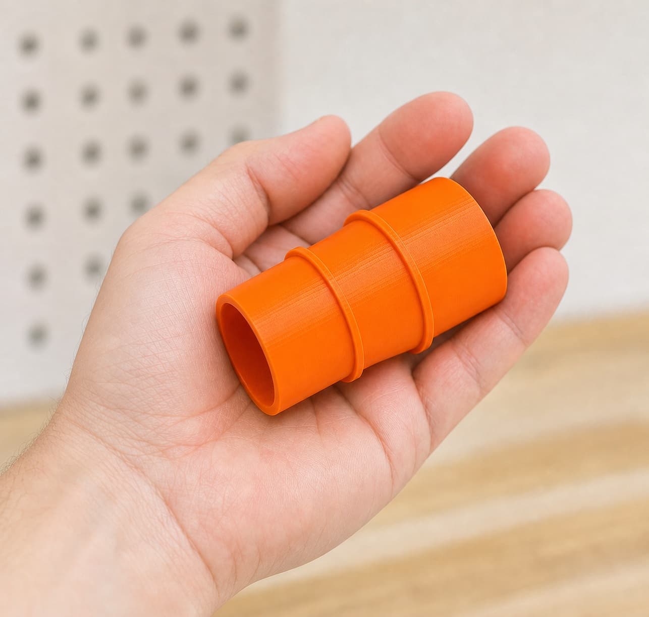 The 58862 to Bauer 6G Vac dust adapter held in one hand to show its size