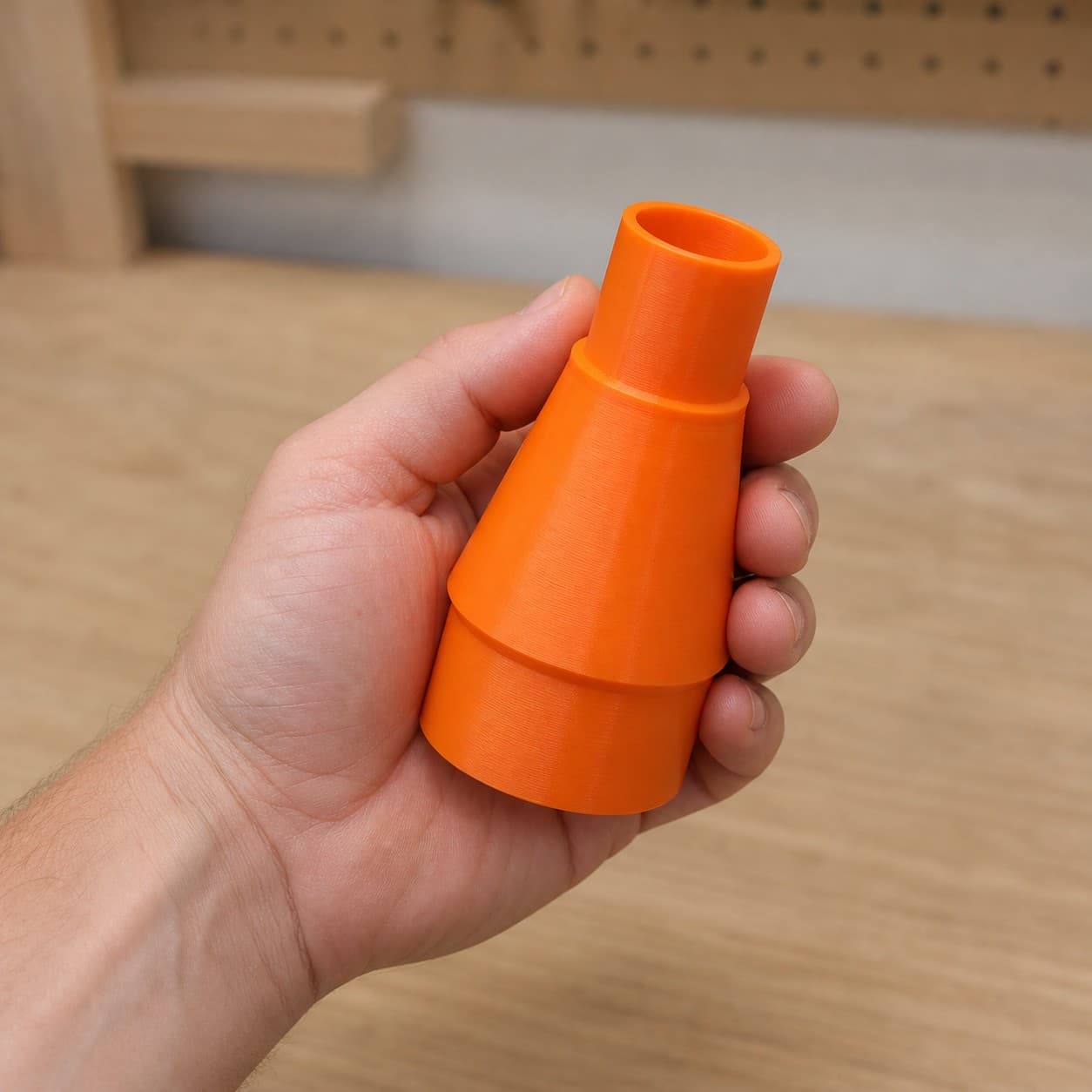 The CMXETAX to 1.25" Duct dust adapter held in one hand to show its size