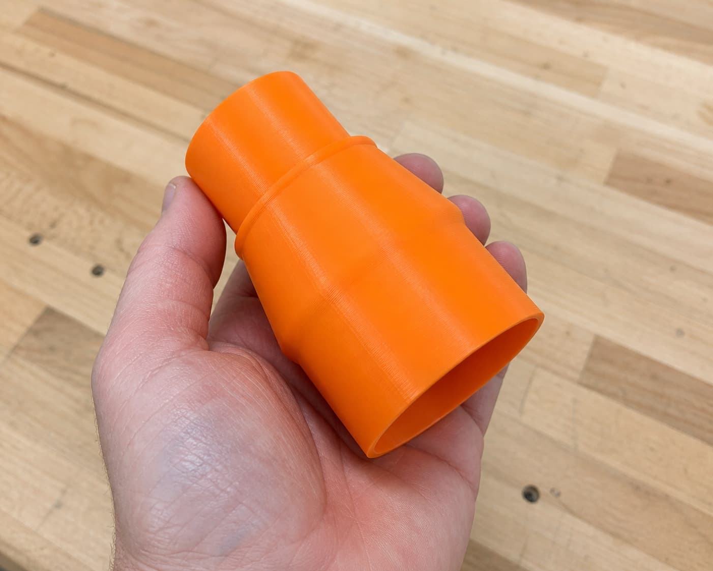 The RTS23 to 1.875" Duct dust adapter held in one hand to show its size