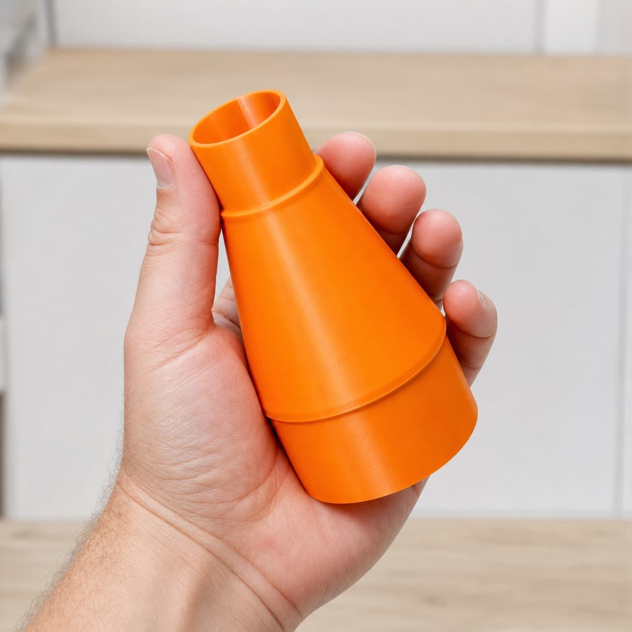 The BW9501-00 to Bosch VAC090AH dust adapter held in one hand to show its size