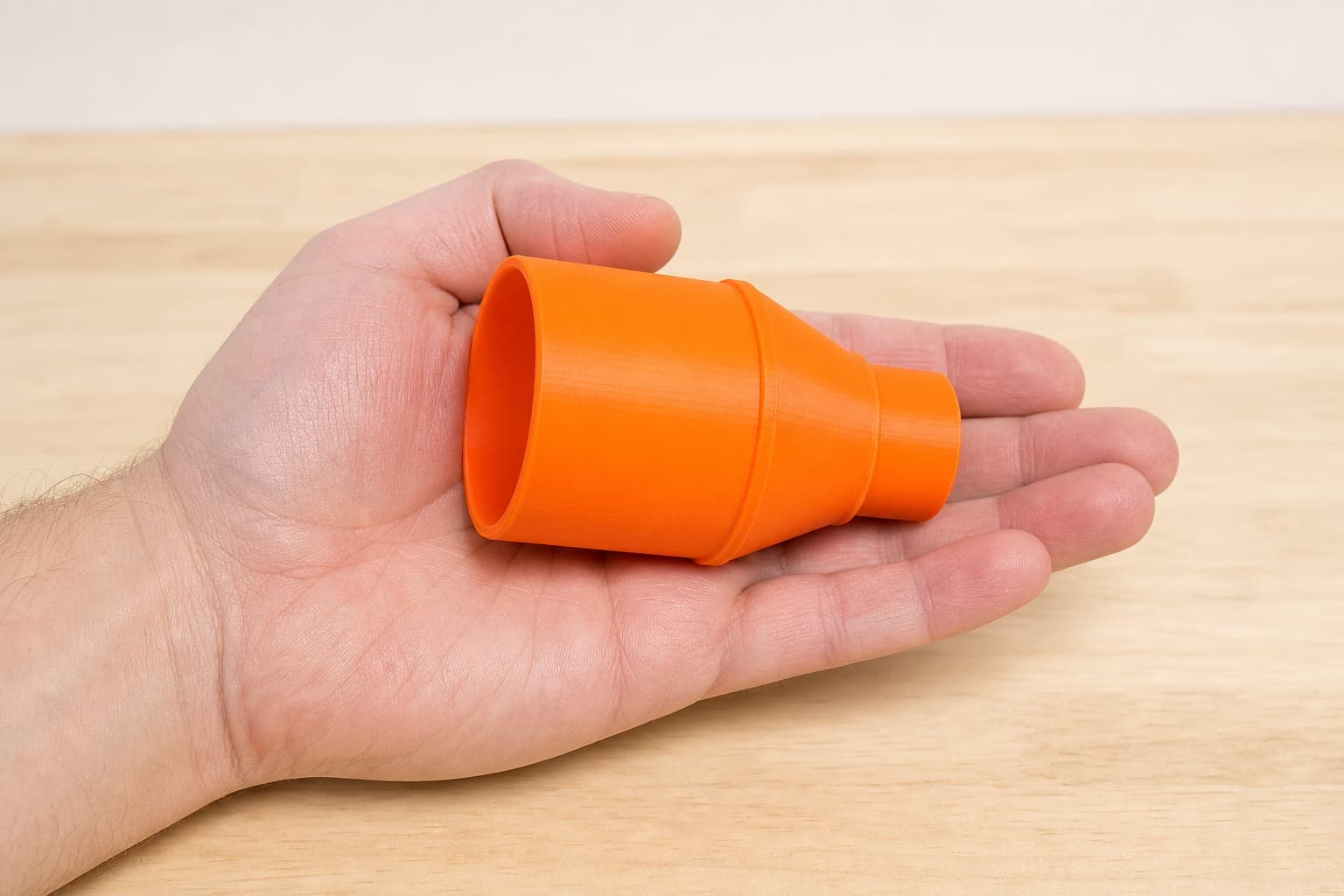 The 2012NB to Craftsman 20G dust adapter held in one hand to show its size